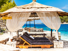 Private beach with deck chairs and canopy.