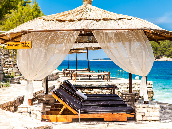 Private beach with deck chairs and canopy.